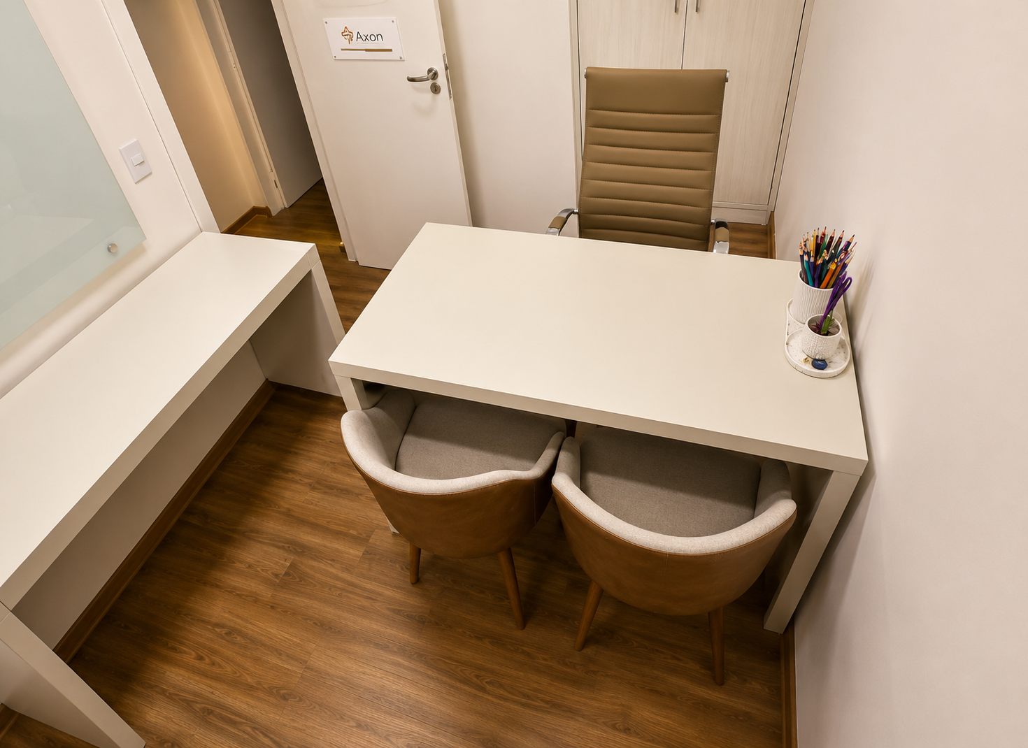 Consultório 01 do Instituto Axon Savant com mesa de atendimento e armário.