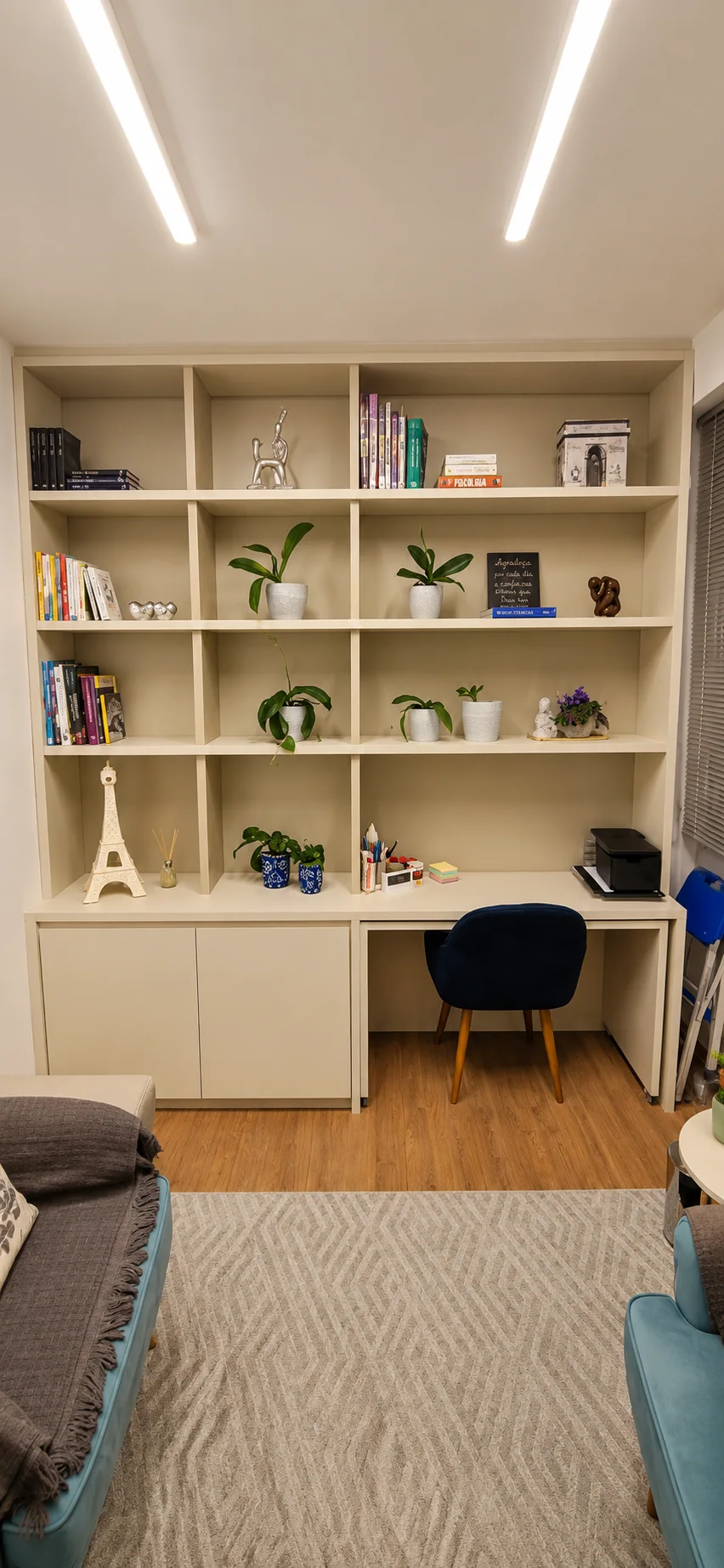 Consultório 02 do Instituto Axon Savant com estante, livros, plantas e área de atendimento.